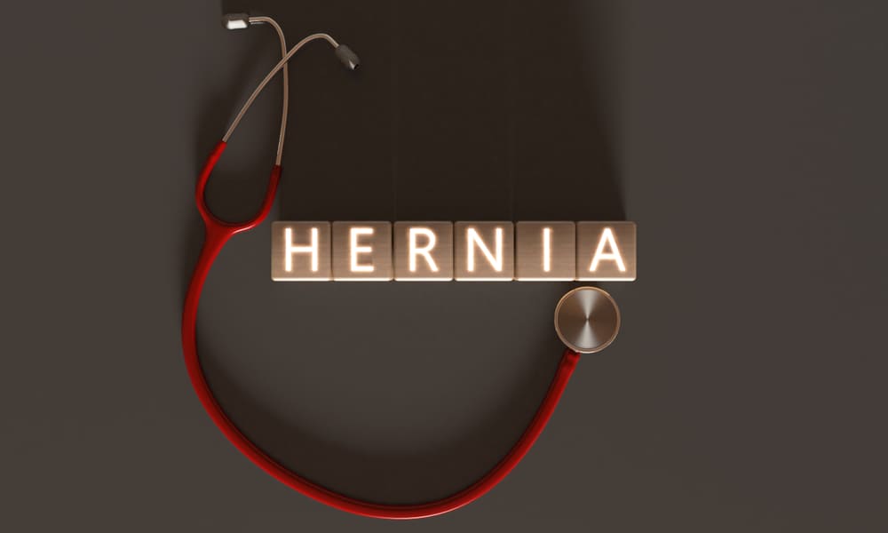 Estetoscópio ao lado da palavra hérnia - hérnia na barriga