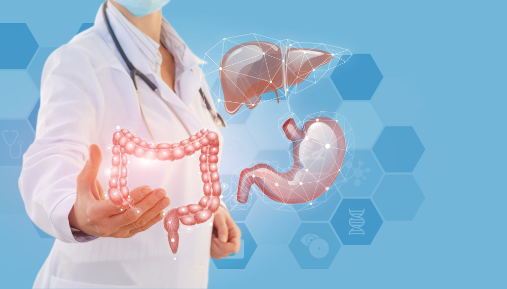 médico ao fundo com ilustração de órgãos do aparelho digestivo