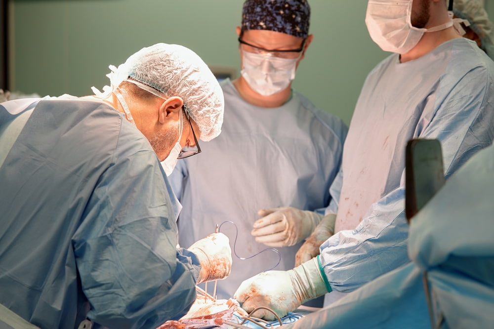 Médicos cirurgiões realizando cirurgia.