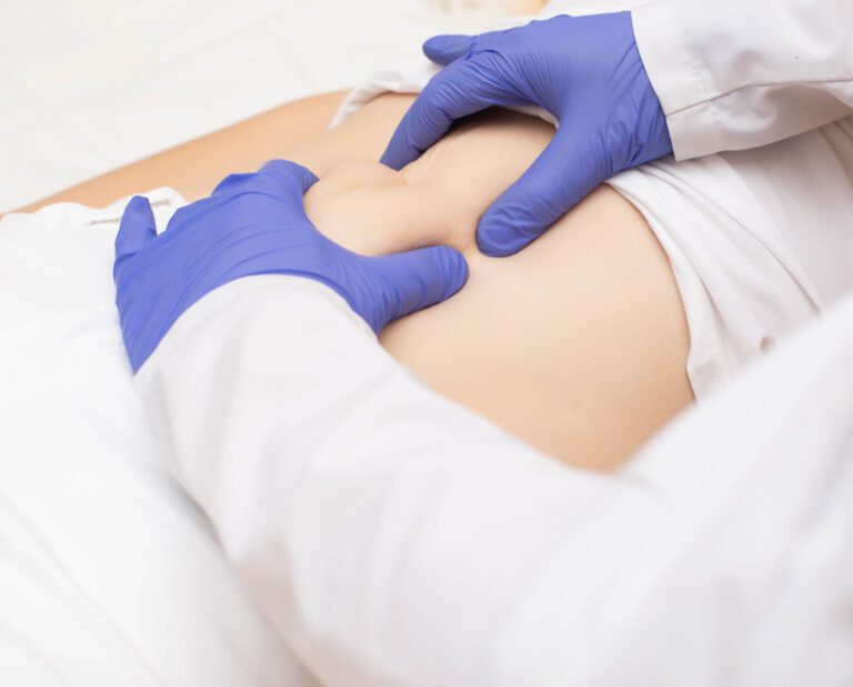 Médico examinando paciente - sintomas de hérnia na barriga