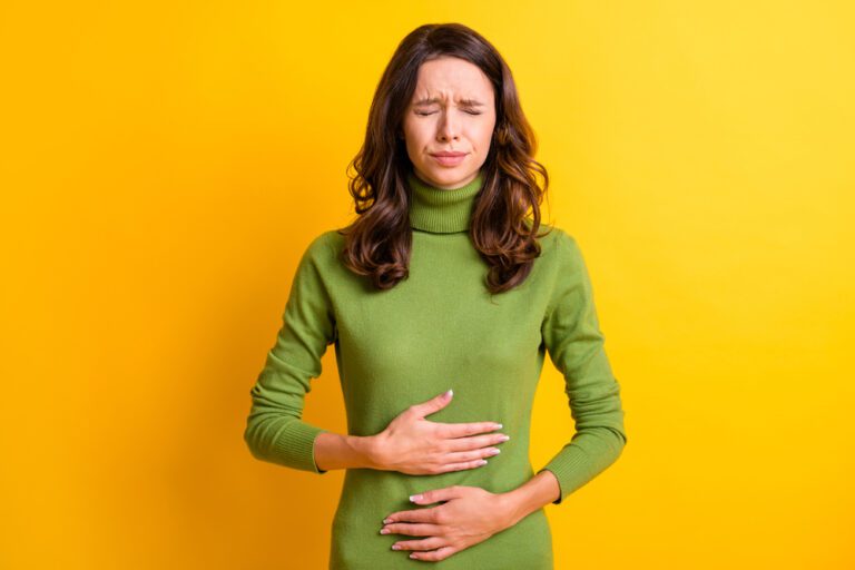 imagem de uma mulher com dor|Dor após cirurgia de hérnia: Tesoura de um cirurgião