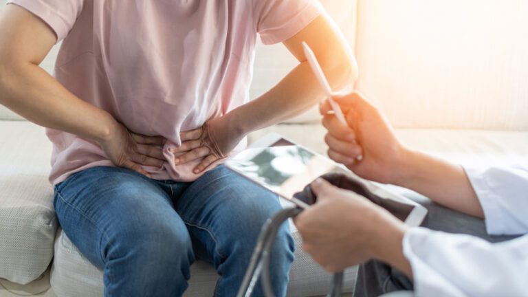 Homem sentado com as mãos na barriga hérnias abdominais