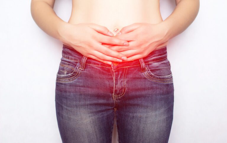 Mulher sente um dos sintomas de hérnia: saliência na barriga