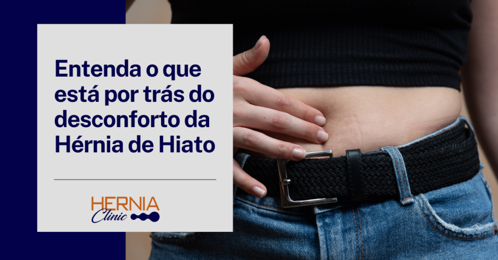 
Pessoa tocando a região abdominal abaixo da cintura, sugerindo desconforto ou dor. A imagem foca na área do abdômen, com um cinto preto e calça jeans ajustada.