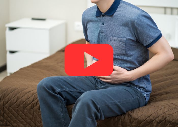 Pessoa pressionando a região abdominal com as mãos, sugerindo desconforto ou dor no estômago.