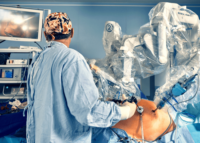 Cirurgião opera sistema robótico em sala cirúrgica durante procedimento minimamente invasivo.